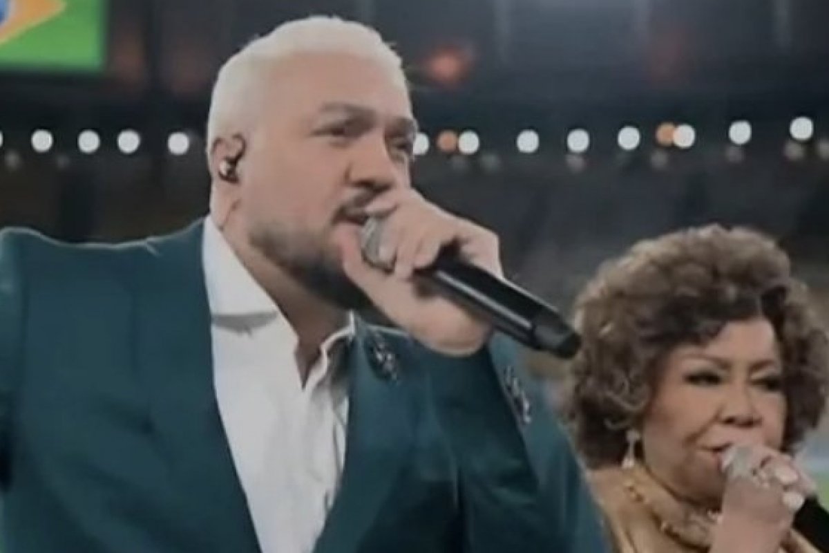 Após cantar hino em amistoso da Seleção, Belo e Alcione viram motivo de críticas e piadas nas redes sociais! 