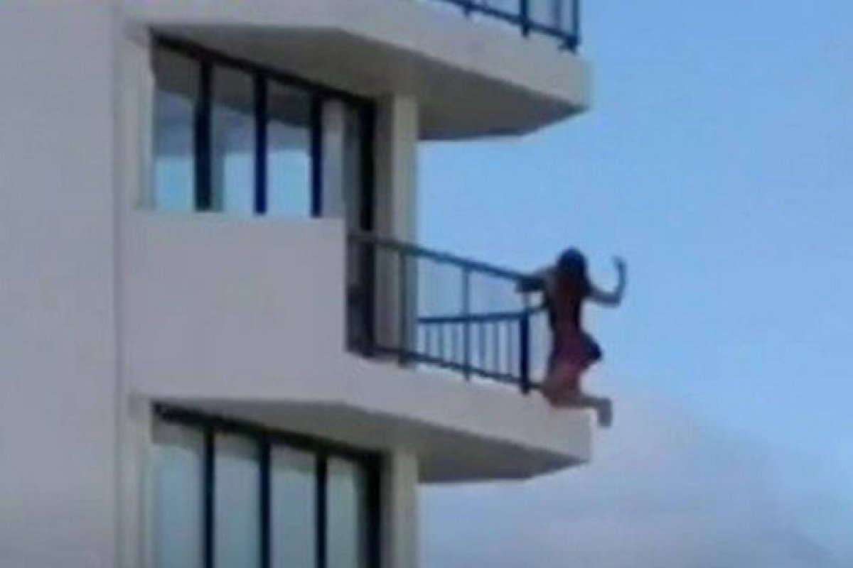 Vídeo: mulher se pendura em sacada de varanda para tirar foto
