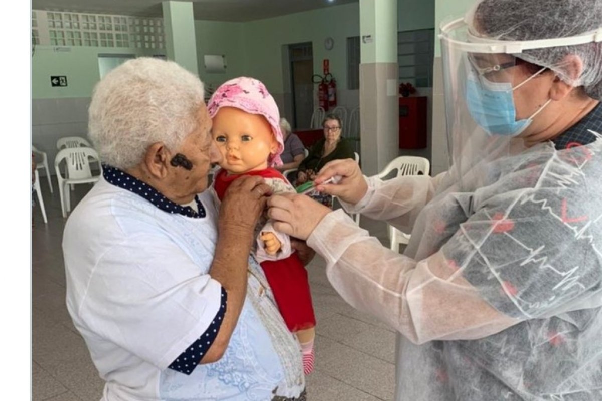 Muito amor! Após ser vacinada contra Covid-19, idosa que vive em abrigo pede que enfermeira 'vacine' boneca