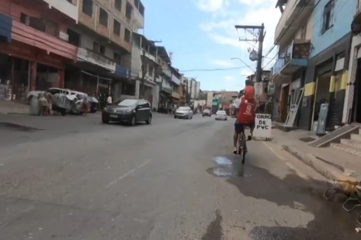 Ciclista circula com criança nos ombros na Av. San Martin, em Salvador 