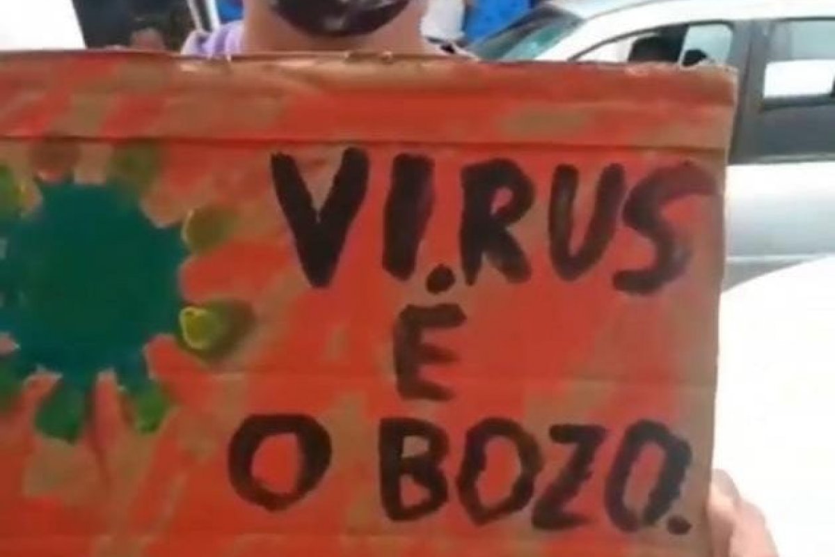 Homem afirma que ganha R$ 20 reais por hora para segurar a placa 'VÍRUS É O BOZO' em manifestação de esquerda