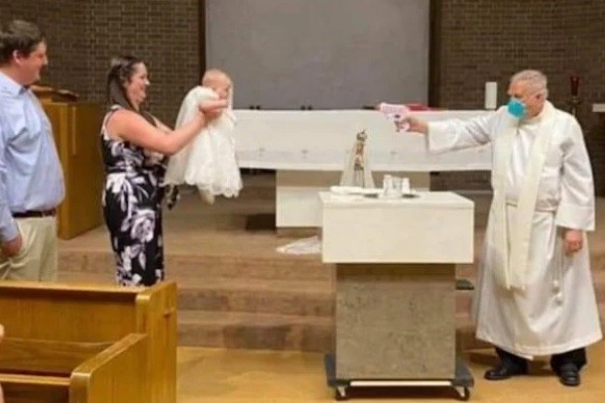 Padre batiza criança com pistola de água benta para manter o ...